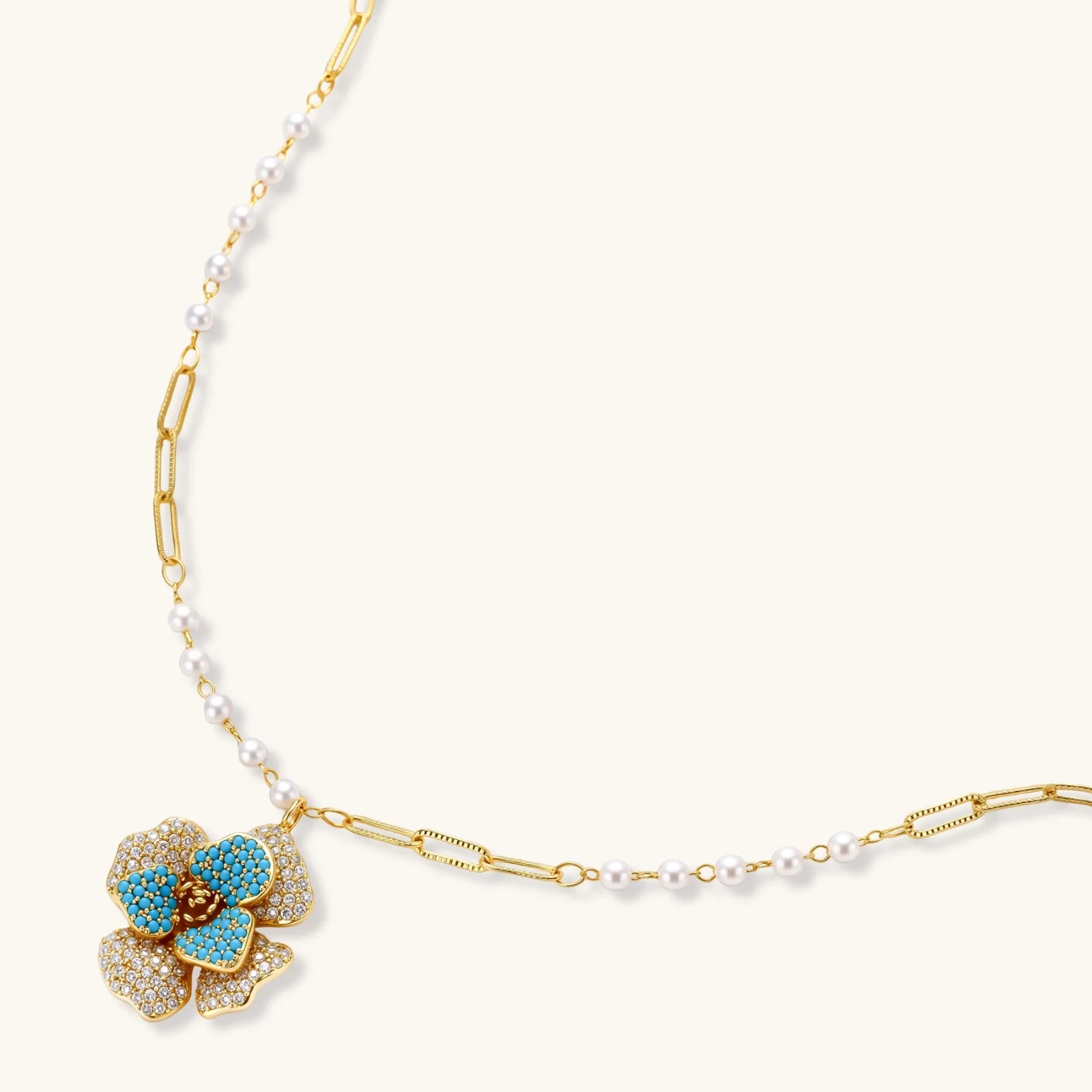 14K gold-plated floral jewelry set with blue cubic zirconia centers and pearl chain details on white background.