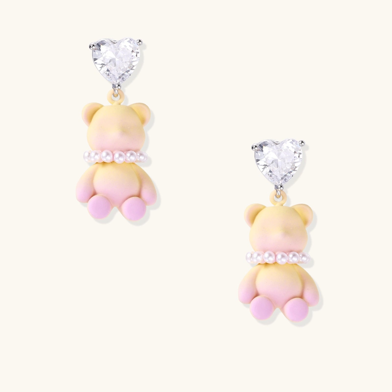Dangle earrings with heart-cut zirconia studs and pastel teddy bear charms with pearl necklace details