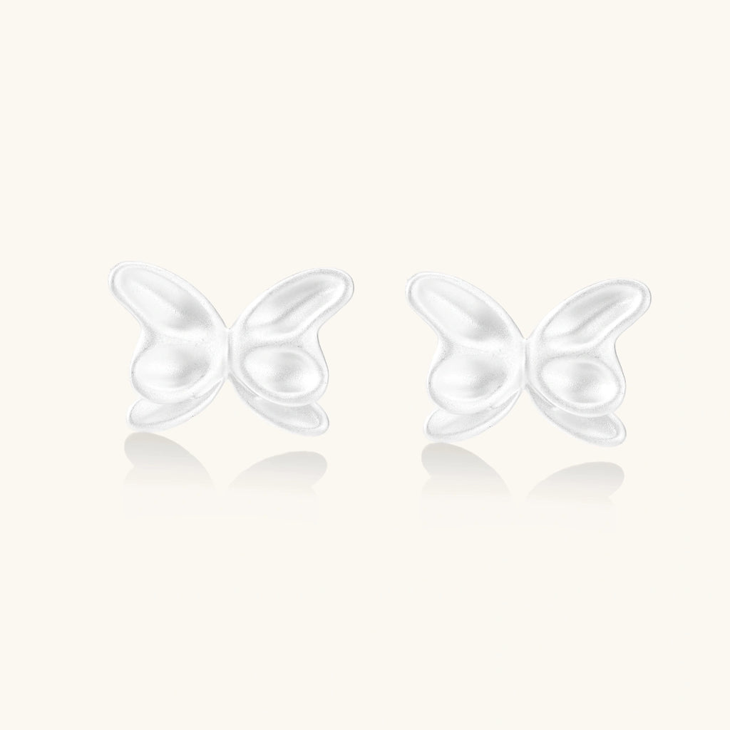 Pair of translucent butterfly-shaped stud earrings with frosted finish and dimensional wing details on white background