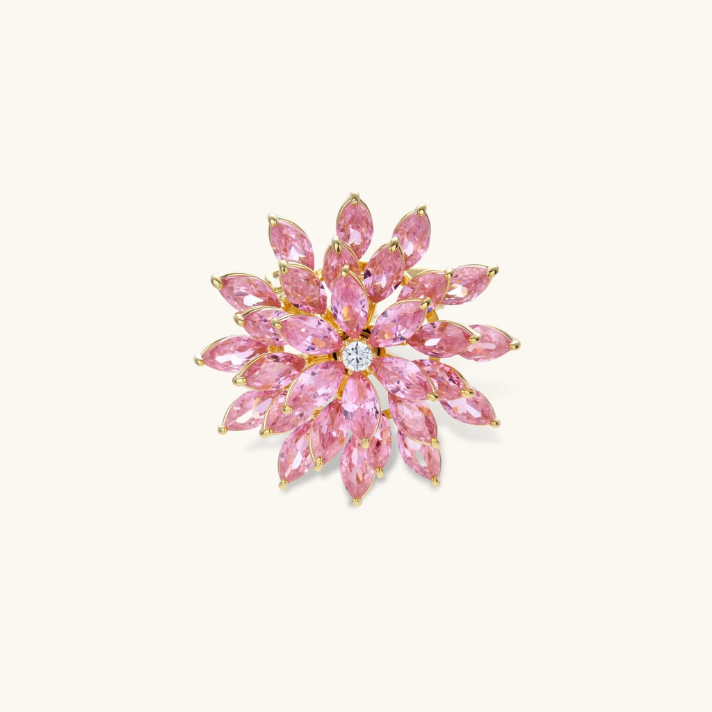 Pink cubic zirconia brooch in floral starburst design with palladium-plated copper setting on white background.